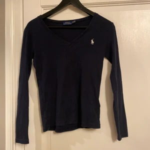 Polo Ralph Lauren  - Säljer en polo Ralph lauren tröja då den inte längre kommer till någon användning. Superfin marinblå tröja med en v-ringning, storlek xs. 