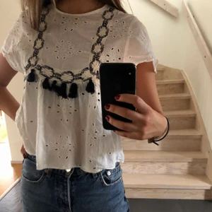 Blus med broderade detaljer - Säljer en blus från zara med broderade detaljer och tofsar, är i fint skick! Är i storlek XS men passar även S, säljer för 80 kr + frakt!❤️