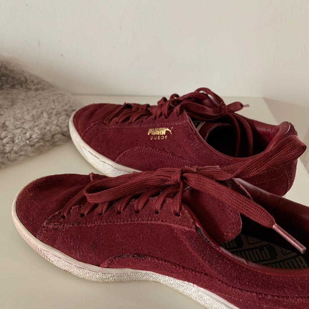 Ett par trendiga Puma Suede Sneakers i färgen vinröd. Dessa är i storlek EU40 och är använda ett fåtal gånger för längesedan. En liten missfärgning på högerskon (se bild 3). Annars ett par super sköna sneakers med en härlig färg till våren/sommarn. Köpare står för frakt. . Skor.