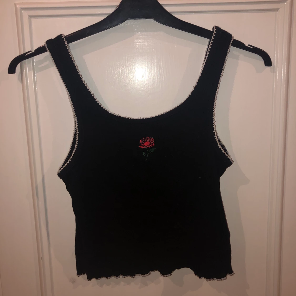 Svart linne med en broderad ros