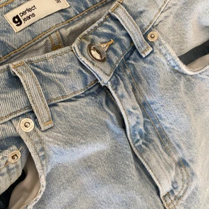 90S HIGH WAIST JEANS - gratis frakt - Highwaist jeans utan stretch med slitna knän. Jeansen är ljusblåa och har en 90-talsinspirerad, rak passform och hög midja. Byxorna är för stora för mig, använda 2 gånger så är i nyskick. Nypris är 599kr på Gina Tricot.  