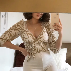 mönstrad blus strl 34  - beige / vit mönstrad blus, knyter till rosett. 