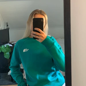 Sweatshirt från The North Face, strl s - Turkos sweatshirt från The North Face med ett coolt rosa tryck på ryggen, som tyvärr inte kommer till användning. Använd en gång, så i väldigt bra skick✨