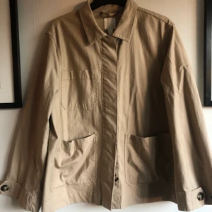 Trench från H&M - säljer en overshirt / jacka i trenchcoat-material från HM i storlek 40! Beroende på önskad fit så skulle jag säga att den funkar för personer med XS-medium! Använd en gång, så ingenting att anmärka på! Material: 97% bomull och 3% elastan
