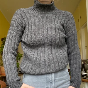 Stickad tjocktröja - En mörkgrå ribbstickad tjocktröja! Tunn men ganska varm, i stretchigt material! Passar mig som är S men även XS beroende på hur man vill ha passformen! 