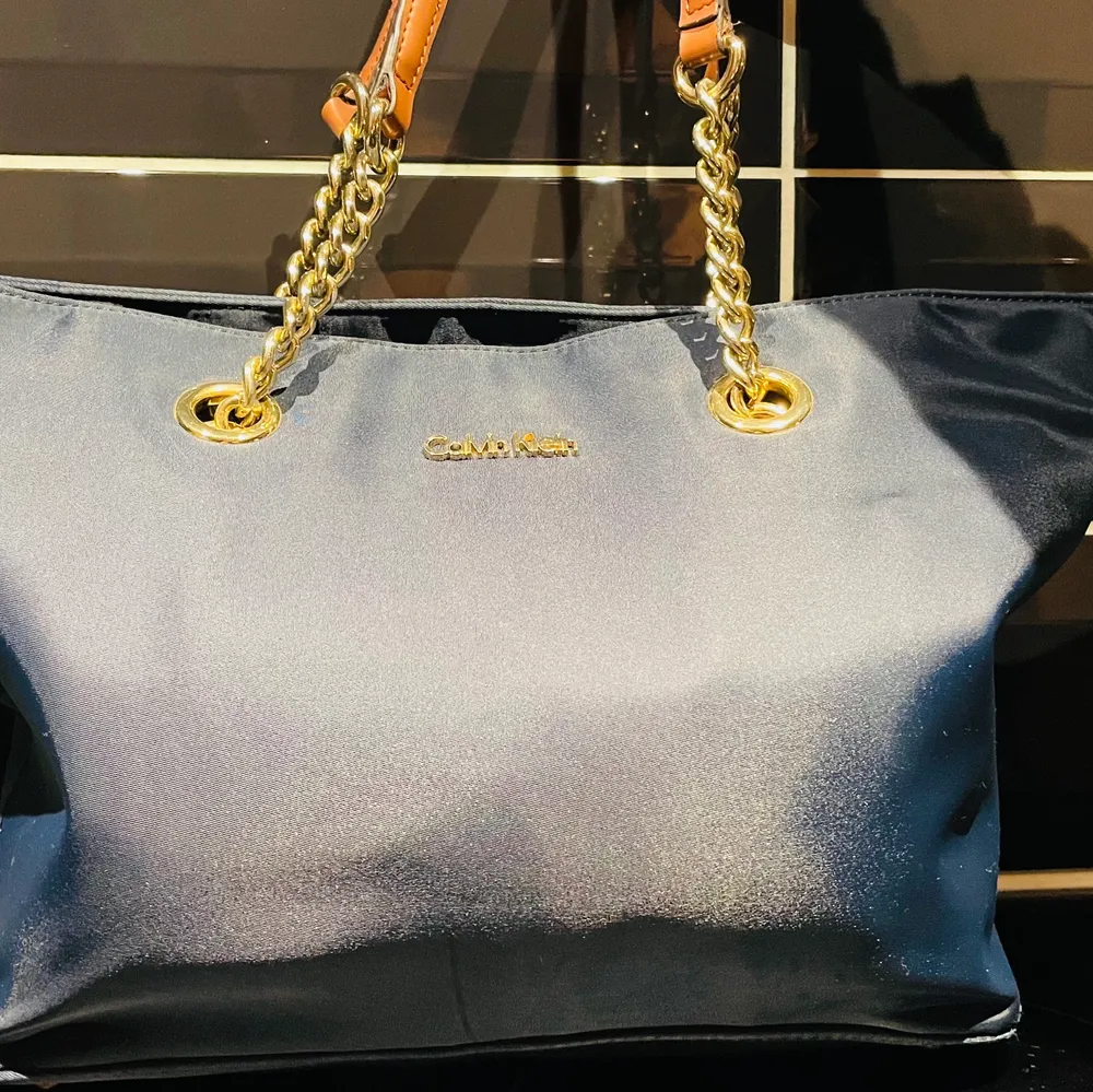 En äkta Calvin Klein väska, använd några gånger själva väskan är som nästan  en helt ny men Väskhandagen är lite slitna men annars är den som en ny väska. . Väskor.