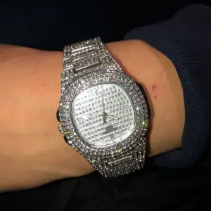En klocka med massvis diamanter på den är silver och den är tjej storlek. Men passar killar med små händer oxå 