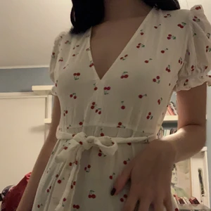 Klänning med körsbär  - Supersöt klänning med körsbär på. Skärp följer med men går att ta av 