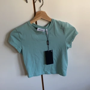 Blågrön topp, weekday❣️ - En fin, croppad tshirt från weekday! T-shirten är aldrig använd, mycket fin färg och helt ny💓 Den andra bilden är på samma modell som denna tröjan, men i en annan färg!