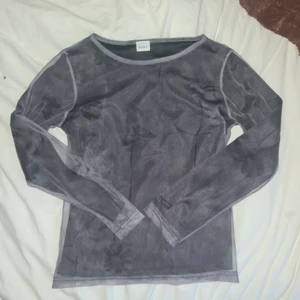 Grå svart meshtopp med blommotif - DEN ÄR INTE GLITTRIG!!! Det är bara blixten som får det att se ut så. Inga synliga defekter. Skriv om ni har frågor eller vill se fler bilder.