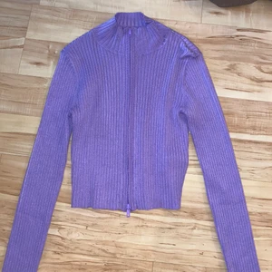 Lila tröja med dragkedja  - Säljer denna långärmade lila tröjan med dragkedja. Den har en snygg lila färg o sätter sig snyggt efter sin kroppsform. Skulle säga att den passar allt från XS-L. Tröjan är aldrig använd och köpt på Monki. Köparen står för eventuell frakt💕