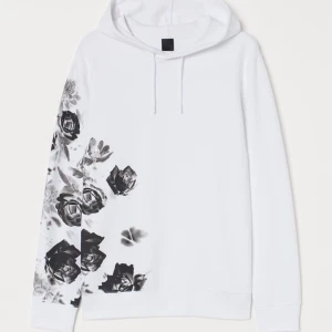 Hoodie med tryck - En helt ny hoodie från H&M. Precis som den på bilden men svart och med vita rosor. Hund finns i hemmet. Nypris 299:-