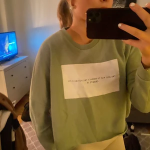 Grön sweatshirt med tryck på - Säljer min nästan helt oanvända gröna sweatshirt med ett fint vitt tryck på! Den är i nyskick 