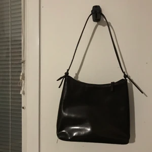 Brun väska  - Mörkbrun axelväska (ljusare i verkligheten) väldigt snygg, men har gjort sitt för mig! Materialet är något fakeläder liknande! 