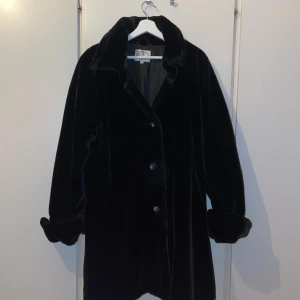 Sammetsrock / kappa svart - Kolsvart kappa i mjuk teddy / sammet. För stor för mig som är en M. Så passar L / XL. Väldigt härlig kappa i fin kvalitet som tillhört en äldre classy dam! 