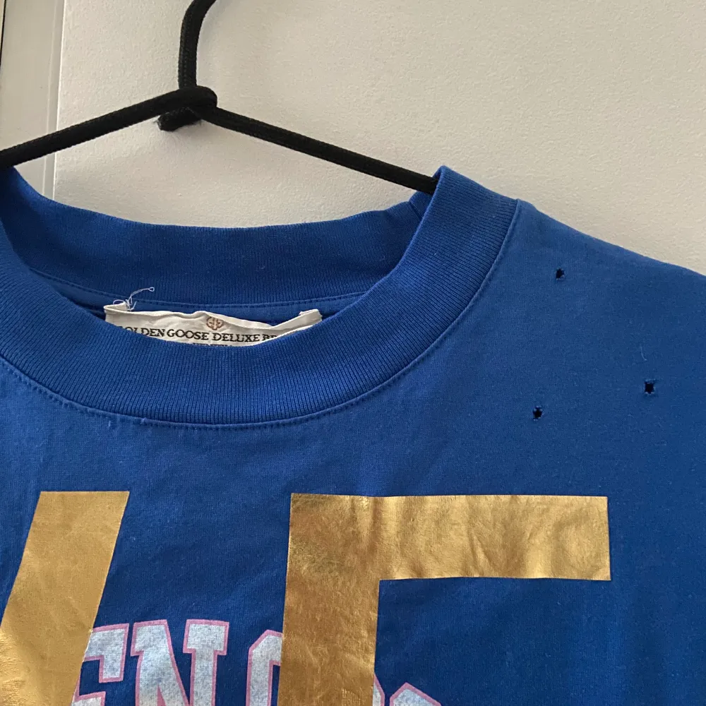 Golden Goose deluxe brand t shirt ”university print t-shirt” köpt på Wakakuu för ca 1300 kr. unik då den är från aw 18 kollektionen och inte säljs längre🤍 Hålen är en del av designen, modellen är oversized så passar xs-m. T-shirts.