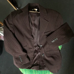 Brunrandig kavaj från Wera - Säljer den här skitsnygga bruna kavajen från Wera. Den har smala axelpuffar och ytterskiktet består av 48% polyester, 48% viskos och 4% elastan. Fodret är av 100% acetat. Kavajen har turtlemönstrade knappar och mindre ”prickade” ränder. Storleken står inte men jag gissar på 34/36. 