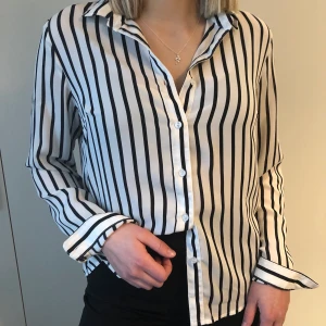 Skjorta - En superfin svartvit randig skjorta. Säljer då den blivit för liten. Köparen står för frakten.