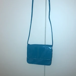 Blå mini väska - Blå mini väska ifrån H&M men säljer den för att jag köpt en likadan i rosa. Väldigt fin och använd 4 gånger. Köpt för 45 kr men säljer för 30 kr