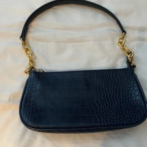 Blå väska ormskinsimmitation - Blå väska i ormskinsimmitation med gulddetalj. Nästan aldrig använd-gott skick. 