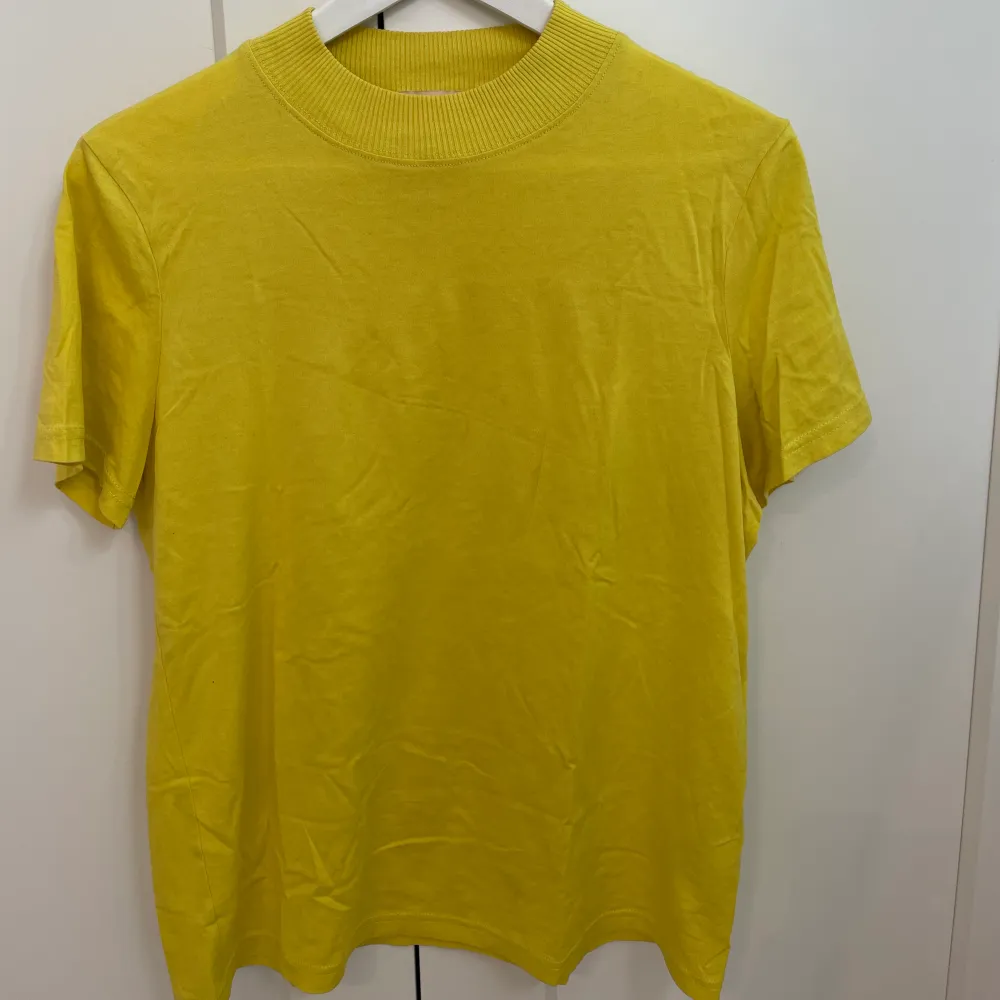 Säljer denna gula t-shirt i silkesbladning från H&M. Den är använd ett fåtal ggr och är i mkt fint skick. Priset är exklusive frakt. T-shirts.