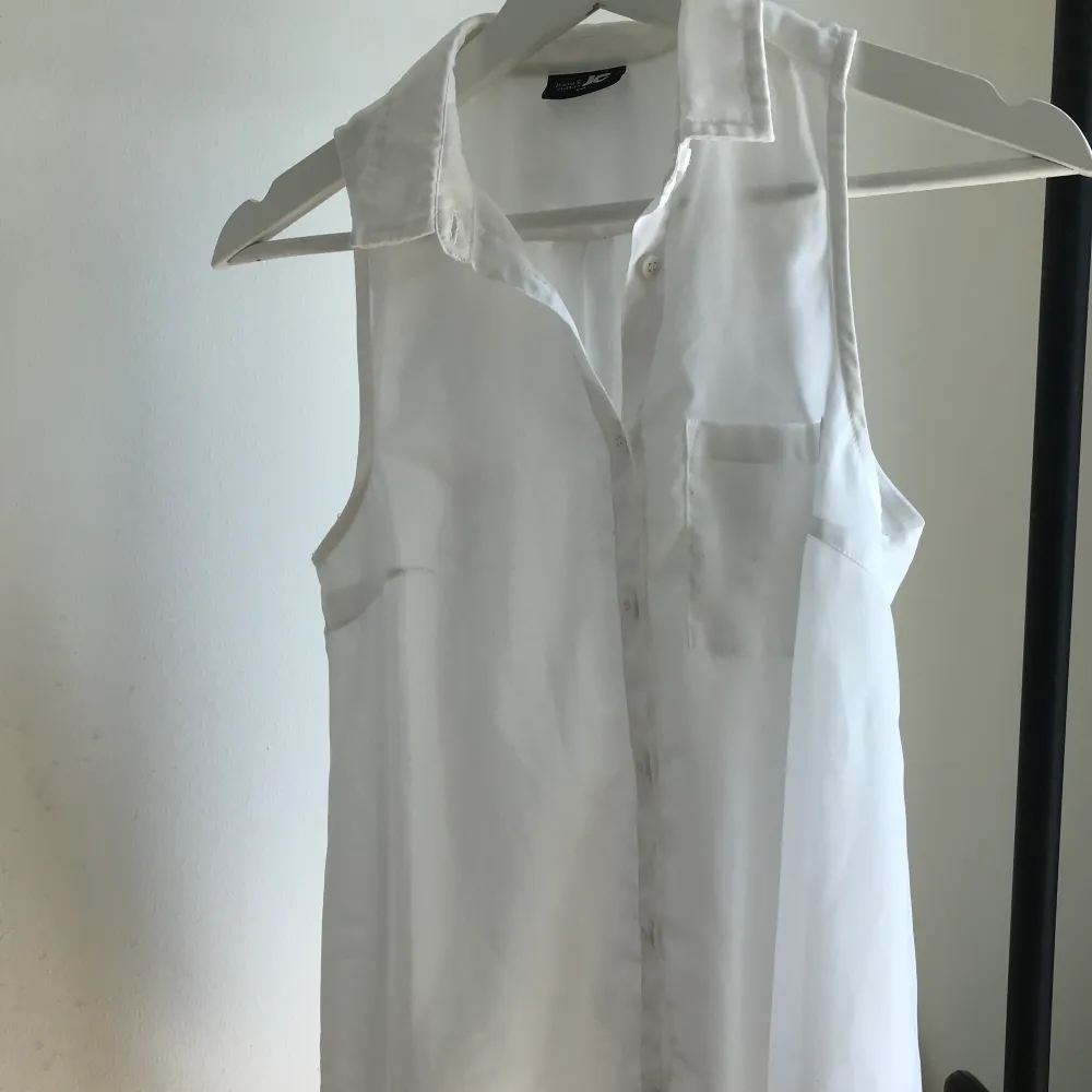 En sval ärmlös skjorta i genomskinligt vitt tyg. Står att det är XXS men jag tycker den är som XS. . Blusar.