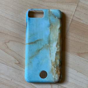Ett skal från märket holdit som har grön/blåa och gula marmor/sten detaljer. Passar till både iPhone  6 och 6s. Lite slitet eftersom det är välanvänt. 