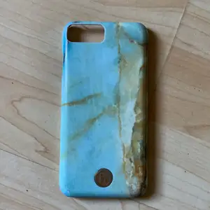 Ett skal från märket holdit som har grön/blåa och gula marmor/sten detaljer. Passar till både iPhone  6 och 6s. Lite slitet eftersom det är välanvänt. 