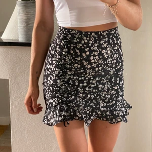 Blommig kjol - En helt ny supersöt kjol i blommigt mönster med en dragsko på ena sidan, tyvärr lite för liten för mig därför säljer jag den. Storlek XS.