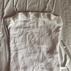Vitt linne volanger - Supergulligt litet linne med volanger från H&M som jag köpte förra året men inte har använt mer än en gång❤️💗💕 justerbara band, fråga om ni undrar något! 