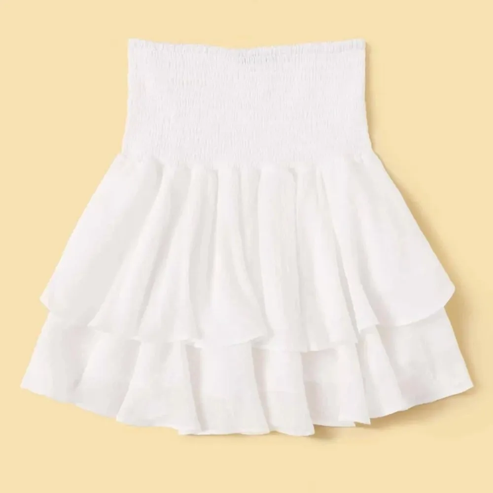 jättefin vit kjol med volanger! den är storlek s men är väldigt stretchiga i midjan! bud startar på 75 kr och måste höjas med minst 10 kr för varje bud! köpare står för frakt som ligger på 45 kr. Kjolar.