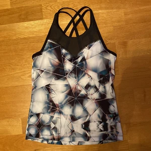 Tränings linne - Ett tränings linne med inbyggd träningstopp. Fint korsande på ryggen. 