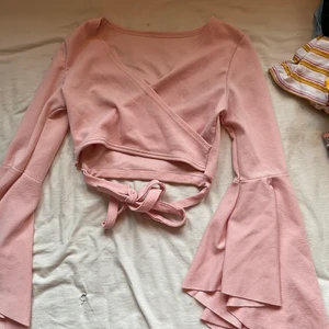 Rosa tröja - Världens vackraste tröja. Perfekt nu till sommaren eller fest. Den är v ringad och går ut i armarna. Den är justerbar. Man kan antingen knyta smörerna där framme eller i ryggen. Tunn och luftig. Originalpris:139