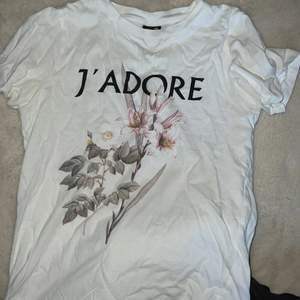 Vit T-shirt från Gina tricot. Den har ett blom tryck på och är i storlek xxs. 