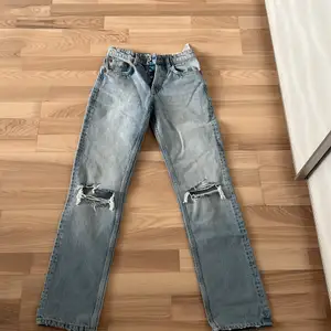 Helt oanvända jeans från Zara som tyvärr är för små. Dom är mid-rise jeans full length som har hål vid knäna. Dom har en fin ljusblå färg. Köpt för 400kr. Köparen står för frakten