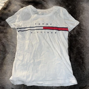 Tommy Hilfiger T-Shirt  - Vit tröja från Tommy Hilfiger, sänkt pris pga liten fläck på axeln, se bild. 