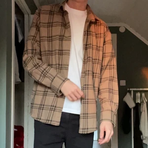Pull&Bear skjorta - Pull & Bear skjorta i mycket bra skick och använd ett fåtal gånger och inga synliga fel. Storlek M, modell är 186 cm. Färg: Beige/brun/svart. Om du undrar mått eller fler bilder är det bara att slänga iväg ett DM. 