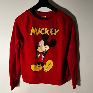 Äkta Disney Mickey Mouse Sweatshirt Röd  - En äkta Musse Pigg Disney-sweatshirt. Storleken är XL för barn, skulle uppskatta att den ungefär är en liten S för män. Fler bilder/mer info kan skickas på förfrågan. Fraktas spårbart med postnord, andra företag kan ordnas vid förfrågan.
