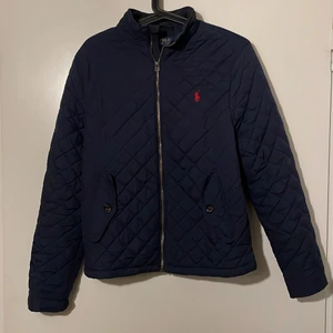 Blå Ralph Lauren jacka - Kort modell, blå Ralph Lauren. Fint skick. Storlek ”18-20” - sitter som en XS för herrar eller 164 för barn.