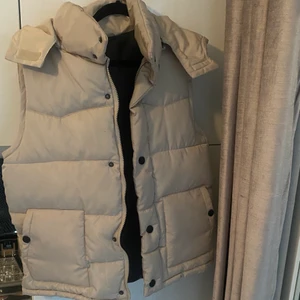 Väst med luva - Väldigt fin väst med luva, endast använd en gång. Har en pytteliten fläck som knappt syns (går säkert att få bort).