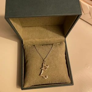 Maria Nilsdotter halsband  -  Silvrigt Maria Nilsdotter halsband i bokstaven E 