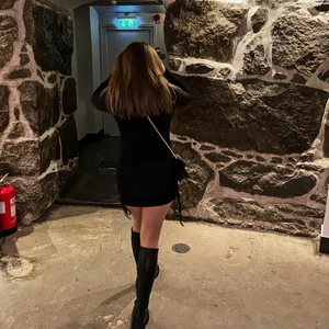 Svart klänning  - Svart tight klänning med snörning på sidorna så man kan justera hur lång eller kort man vill ha klänningen. 