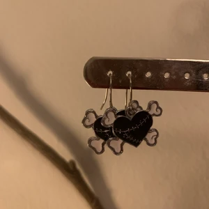 Svarta hjärtörhängen - Ett par ascoola örhängen föreställande svarta hjärtan med benknotor💗💗💗