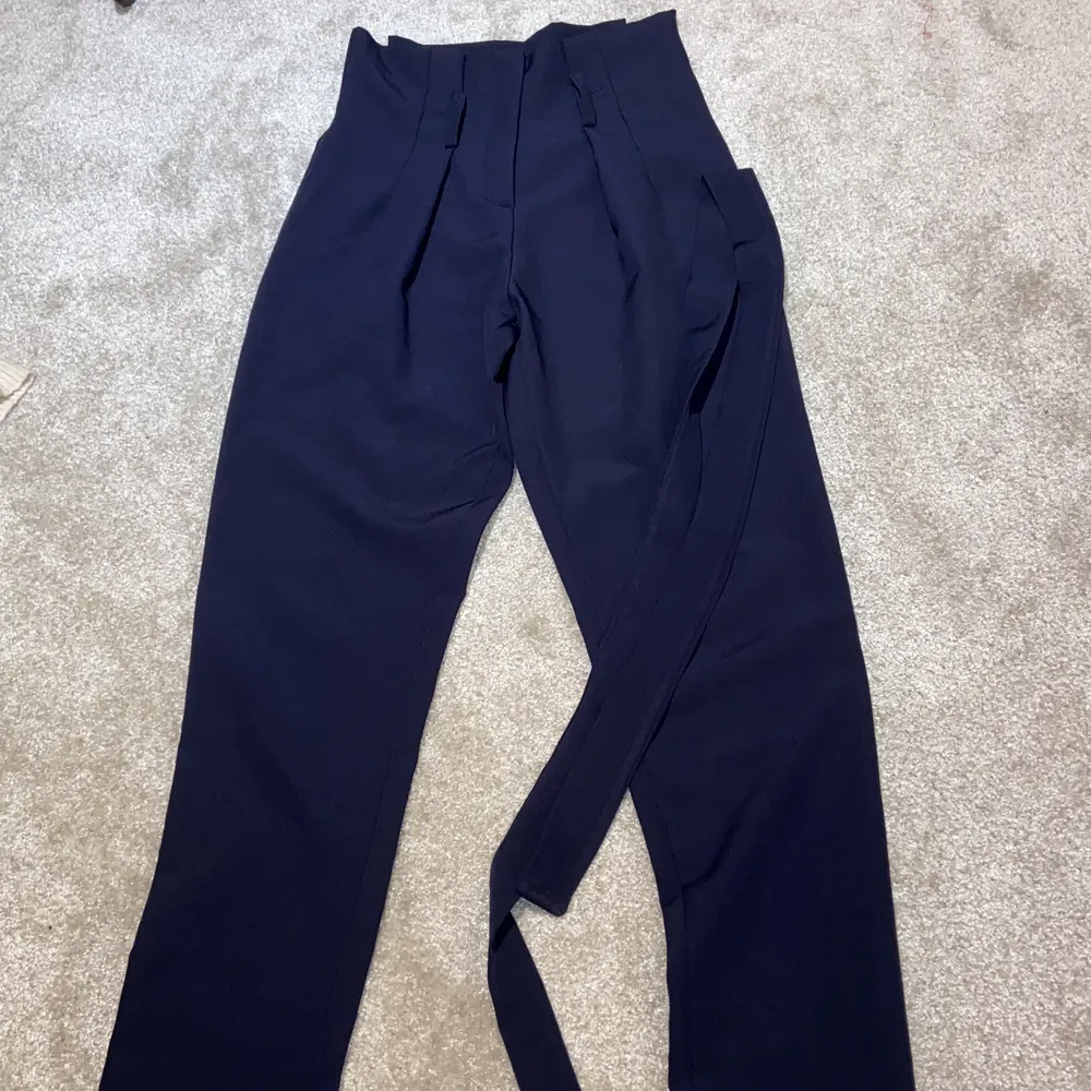 Mörk blåa kostym byxor i nytt skick aldrig använts kommer med ett volang bälte i samma färg storlek S. Jeans & Byxor.