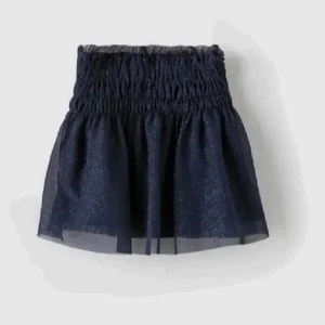 Glittrig kjol - Säljer denna marinblåa glittrkjolen från zara. Den är i barnstorlek men sitter bra på mig som har storlek S. Man kan ha den som båda kjol och topp!!