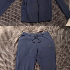 Nike tech tracksuit  - Säljer min nike tech navy blue tracksuit eftersom den var köpt i fel storlek på plick. Dragkedjan har gått av men det går att sätta på en ny. Byxorna är storlek s och tröjan är i xs. Helst vill jag att man köper hela tracksuiten men det går också att köpa klädesplaggen var för sig ( kolla mina andra annonser) köparen står för frakt.
