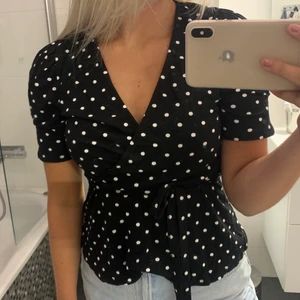 Söt prickig topp - Säljer denna jättesöta prickiga topp från Gina. Den har ett band man knyter i midjan. Nästan aldrig använd. Storlek S😊