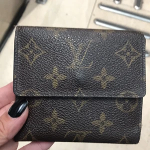 Luis Vuitton plånbok - Underbar gammal vintage plånbok som fortfarande håller måttet. Den var naturligtvis jätte dyr när den köptes men det har gått många år nu, då har den istället blivit vintage…. Jag har svårt att sätta ett pris. Ge mig gärna förslag. Jag tänkte mig 1,500 iaf…. Den har 6 st fack för kort samt två fickor ”bakom”, sedelfack och myntfack. Den är i jätte bra skick, kan nästan säga nyskick om det inte var för att texten har bleknat (se foto 3) så hör av er till mig om ni är intresserade!!