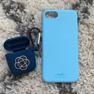iPhone skal och airpods skal - Säljer ett blått skal från Holdit och ett Airpods skal! Holdit skalet har används fåtal gånger och har små repor men inget som man lägger märke till, det passar till iPhone 6-8, airpods skalet är köpt på en marknad så det är inget specifikt märke, skalet säljs för 50 kr och airpodsskalet för 30 kr🌸 kom privat för mer bilder eller om ni vill diskutera priset, köparen står för frakt💕
