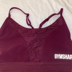 Gymshark sport-bh  - En supersnygg sport-bh från gymshark, stl s. Färgen är vinröd/lila, svårt att se på bilden.